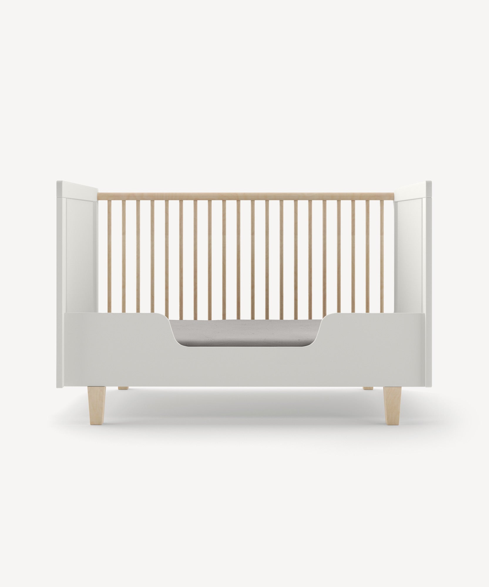 Rhea Toddler Bed Conversion Kit featuring a minimalist white crib design with wooden slats and short wooden legs on a plain white backdrop.