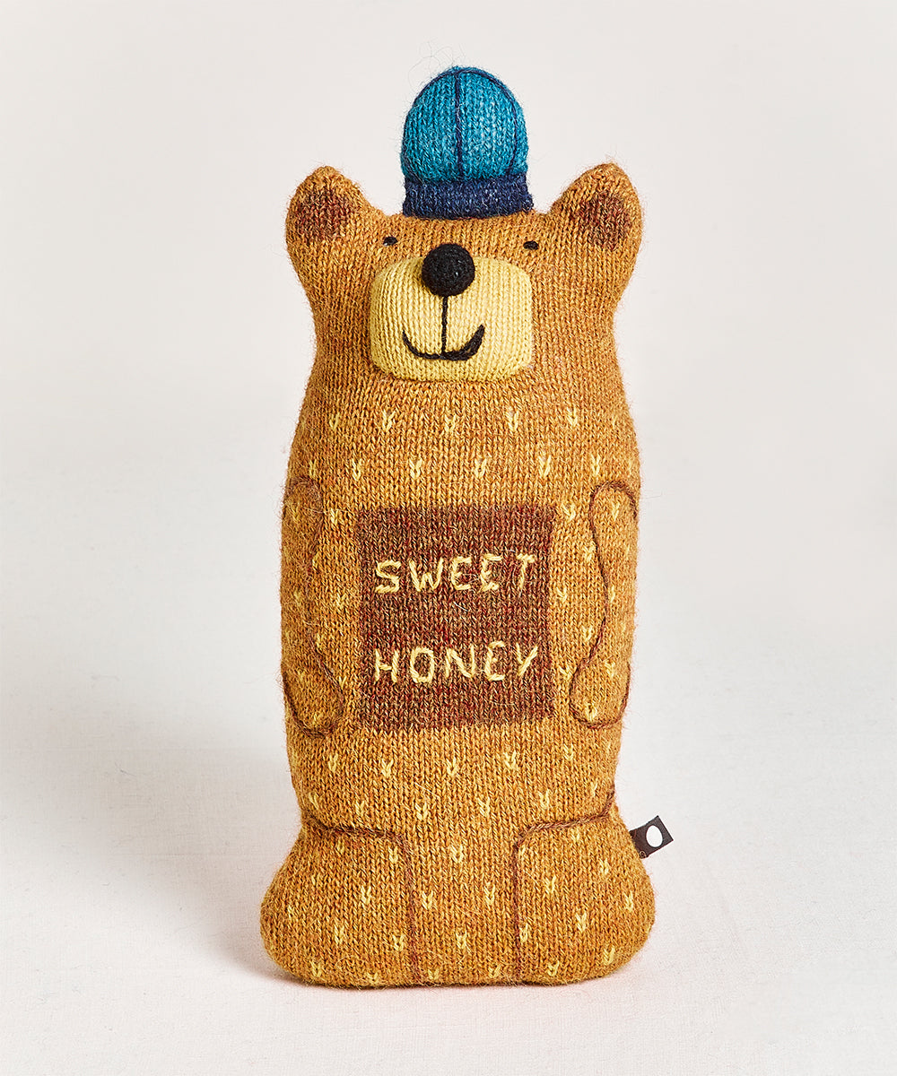 Blue-capped "Honey Bear Pillow" with a smiling face.