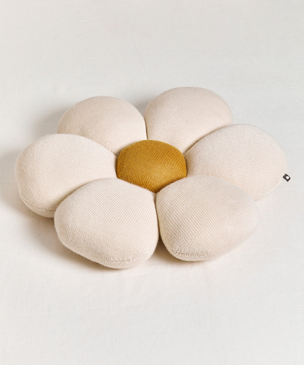 Daisy Pillow featuring a beige flower shape with a yellow center on a light background.